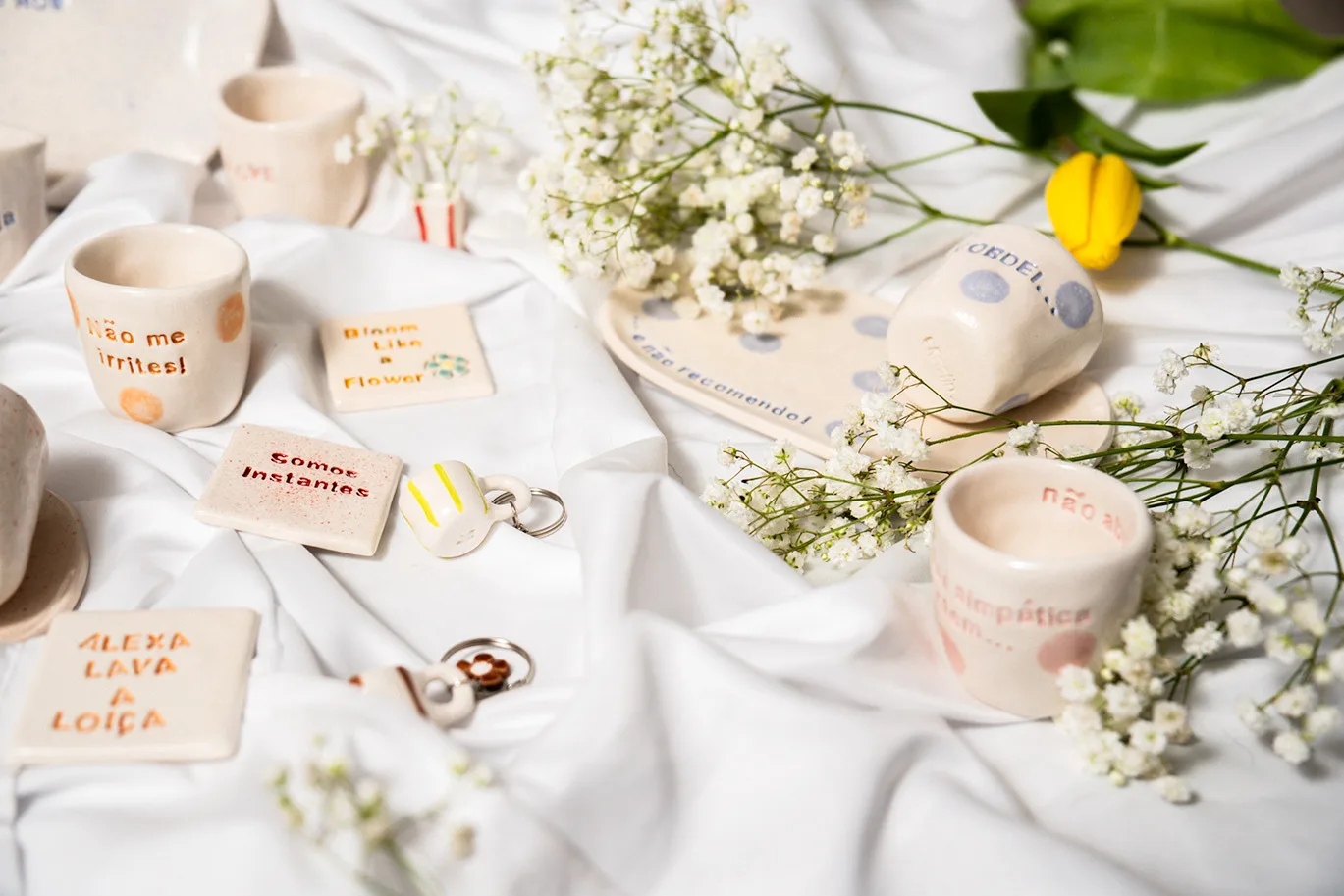 Peças da Kaolin sobre linho branco, com flores secas